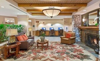 a hotel lobby with a couch , chairs , and a tv . also a computer in the room at Hilton Vacation Club Lake Tahoe Resort South