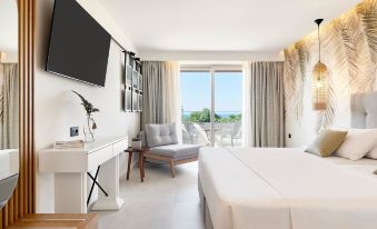 a hotel room with a king - sized bed , a flat - screen tv , and a balcony overlooking the ocean at Iberostar Selection Creta Marine