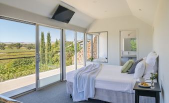 a bedroom with a large bed and sliding glass doors leading to an outdoor patio at Barossa Shiraz Estate