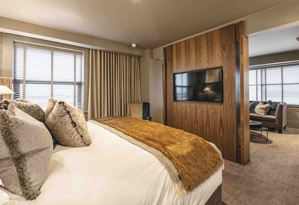 a large bed with a fur blanket is in a room with wooden walls and a television mounted on the wall at Dakota Eurocentral