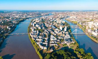 aerial view of a city with buildings and bridges on the banks of a river at Ibis Nantes Saint-Herblain