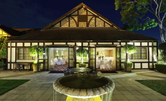a large fountain in front of a building , surrounded by tables and chairs for guests at Peppers the Hills Lodge