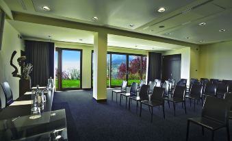 a conference room with rows of chairs arranged in a semicircle , and a television mounted on the wall at Lefay Resort & Spa Lago di Garda