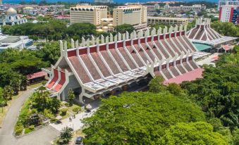 aerial view of a large building surrounded by trees and other buildings , with people walking around the area at Putatan Platinum Hotel