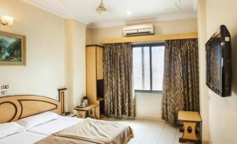 a well - furnished hotel room with a bed , curtains , and a tv , giving a cozy and comfortable atmosphere at Hotel Stay Inn