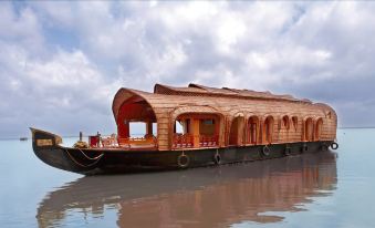 a large wooden boat with an arched roof is floating on a body of water at Paradise Resorts