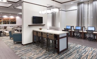 a modern office space with a long wooden desk and chairs , surrounded by multiple computer monitors at Hampton Inn & Suites Chicago North Shore