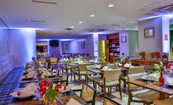 a well - decorated dining room with multiple tables and chairs arranged for a large group of people at San Marino Suites Hotel by Nobile