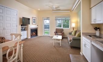 a cozy living room with a fireplace , couches , chairs , and a flat - screen tv . also a dining table in the room at WorldMark Long Beach