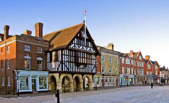 a black and white building with a red roof is situated in the middle of a street at The Cricketers Clavering