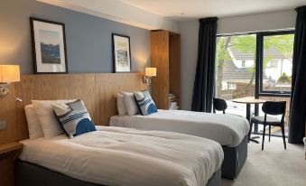 a hotel room with two beds , one on the left and one on the right side of the room at Loch Lomond Hotel