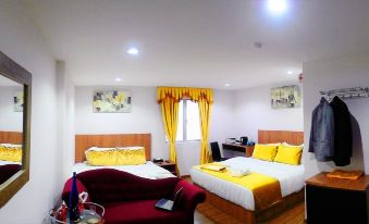 a hotel room with two beds , one on the left side of the room and the other on the right side at Royale Hotel Batu Gajah