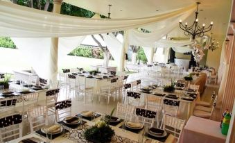 a large white wedding reception with multiple dining tables set up for guests , creating an elegant atmosphere at Hotel Mirage