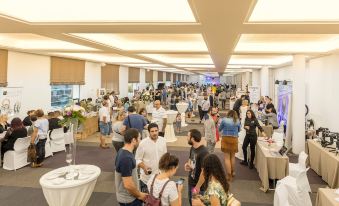 a large room filled with people and various items on display , including vases , flowers , and books at RH Bayren Hotel & Spa