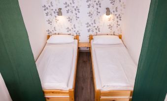 a small room with two beds , one on the left and one on the right at B 94