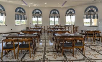 The restaurant is prepared for business with its spacious dining room featuring large windows and tables at Kalipano Country Hotel