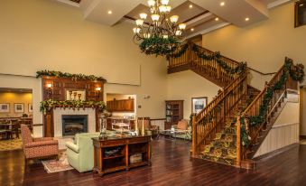 a spacious living room with hardwood floors , a fireplace , and a staircase leading to the second floor at Country Inn & Suites by Radisson, Princeton, WV