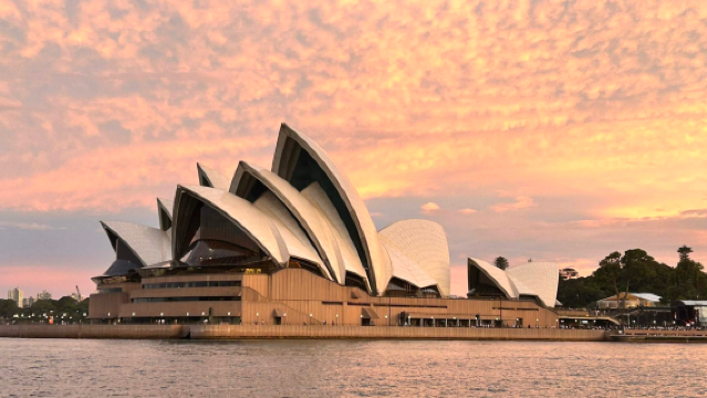 Bootsfahrt bei Sonnenuntergang mit Snacks und Getränken auf dem Luxus-Katamaran "Heaven" im goldenen Moment im Hafen von Sydney, Australien