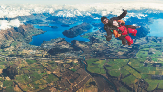 Terjun payung berdua di atas Pegunungan Alpen Selatan dan danau Wanaka, Selandia Baru