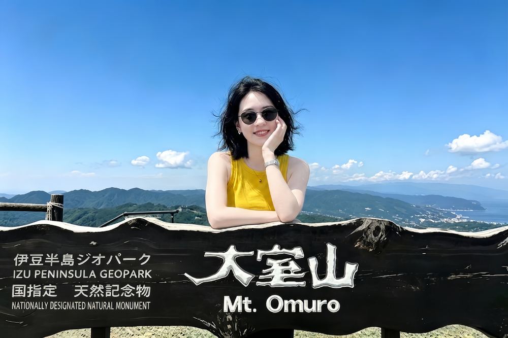 大室山山頂標示牌與伊豆半島全景，遊客打卡《你的名字》取景地
