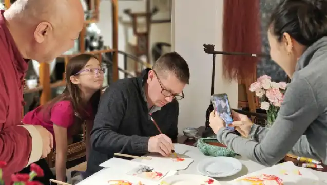Outside the red walls, between brushes and ink, experience the traditional culture of old Beijing and paint fans next to the Forbidden City