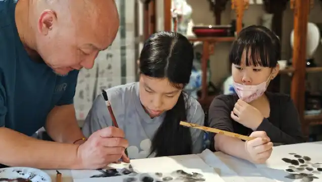 Outside the red walls, between brushes and ink, experience the traditional culture of old Beijing and paint fans next to the Forbidden City