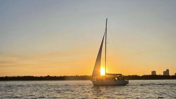 kapal layar kapal layar saat matahari terbenam selama 2 jam dari marina pantai utama di Gold Coast Australia, termasuk makanan ringan dan minuman.