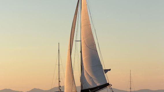 Esperienza di crociera al tramonto sul catamarano Perla di Santorini [Include trasferimento da/per l'hotel, bevande e pasti]
