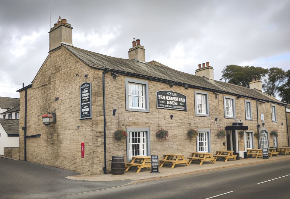 "a brick building with a sign that reads "" the earl 's arms , situated in a town setting" at The Greyhound Hotel