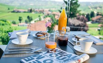 a breakfast table set with a variety of food and drinks , including coffee , juice , and pastries at Arborina Relais