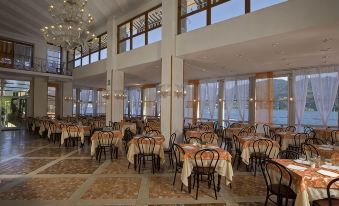 a large dining room with multiple tables and chairs arranged for a group of people to enjoy a meal together at Hotel Bazzoni