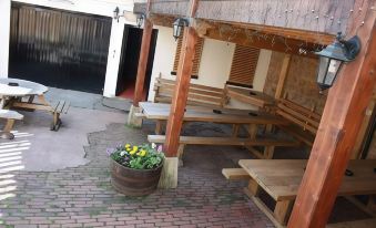 a wooden bench and a flower pot are placed in the middle of an outdoor area with brick flooring at The Brewers Arms