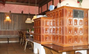 a dining room with wooden furniture , including a table and chairs , and a cabinet filled with various items at Stern