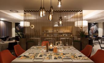 a dining room with a table set for two people , featuring wine glasses and silverware at Winter Garden Hotel Bergamo Airport