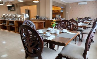 a dining room with a wooden table and chairs , along with various utensils and cups on the table at Mexolie Hotel