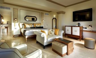 a luxurious hotel room with a large bed , white furniture , and a tv on the wall at Grand Palladium Lady Hamilton Resort & Spa - All Inclusive