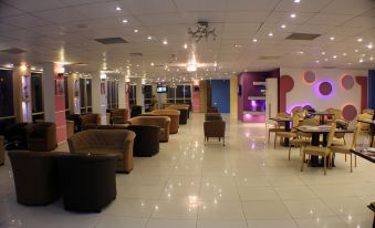 a modern , brightly lit waiting room with several couches and chairs arranged in a spacious area at Seven Days Hotel