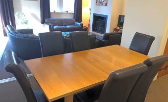 a dining room with a wooden table and chairs , along with a living room area at Irton Hall