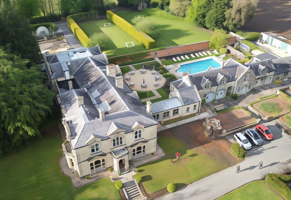 an aerial view of a large house with a pool and tennis court in the background at Beechfield House