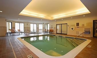 an indoor swimming pool with a large rectangular design and a balcony on the side at Courtyard Boston Raynham