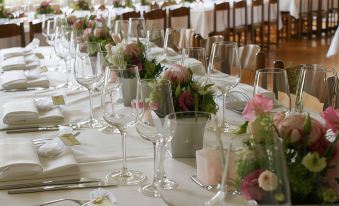 a long dining table set for a formal event , with multiple wine glasses placed on it at Dialoghotel Eckstein