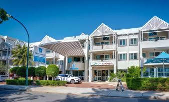 "a large white building with a carport and the words "" capricorn coast apartments "" on it" at Broadwater Resort Como