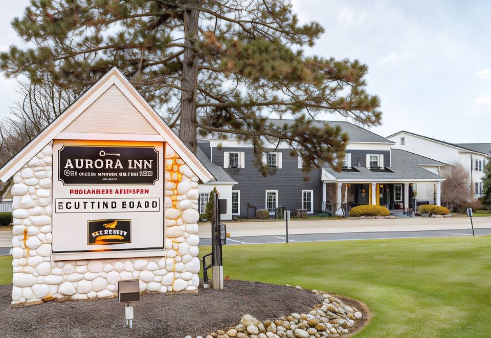 "a hotel with a large sign that reads "" aurora inn "" prominently displayed in front of it" at The Aurora Inn Hotel and Event Center