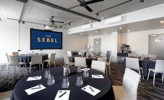 a large conference room with several round tables and chairs arranged for a meeting or event at The Sebel Brisbane Margate Beach