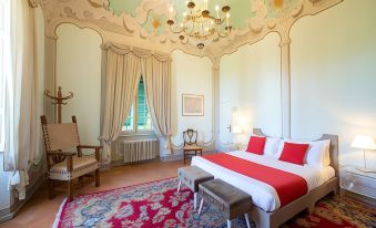 a large bedroom with a red bed , white and gray furniture , and a chandelier hanging from the ceiling at Villa Alta - Residenza d'Epoca Con Piscina
