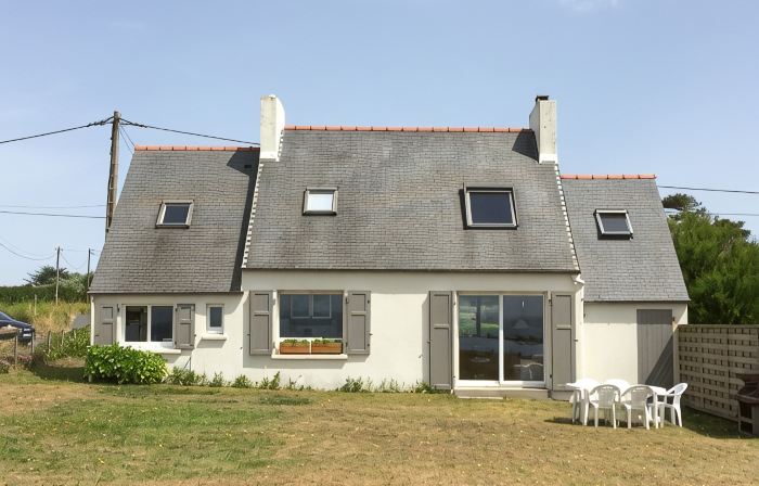 House facing the sea, feet in the water.