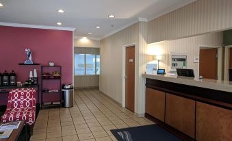 a hotel lobby with a check - in counter , a reception desk , and various items on display at Country Inn & Suites by Radisson, Fairview Heights, IL