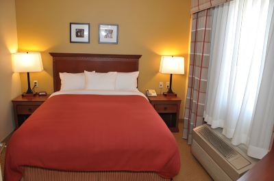 a hotel room with a red bed , two lamps , and framed pictures on the wall at Country Inn & Suites by Radisson, Watertown, SD