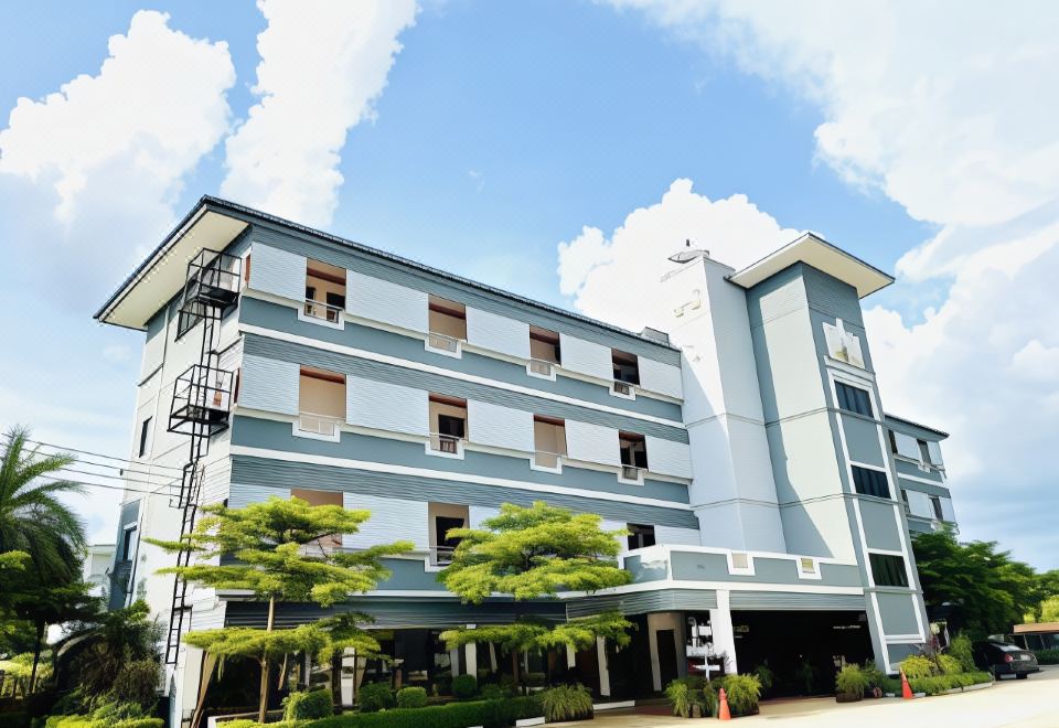 a modern apartment building with multiple floors , situated near a street and surrounded by trees at Thatphanom View Hotel
