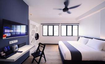a modern bedroom with a large bed , a chair , and a tv . the room is clean and well - organized at Arena Boutique Hotel Kuala Terengganu